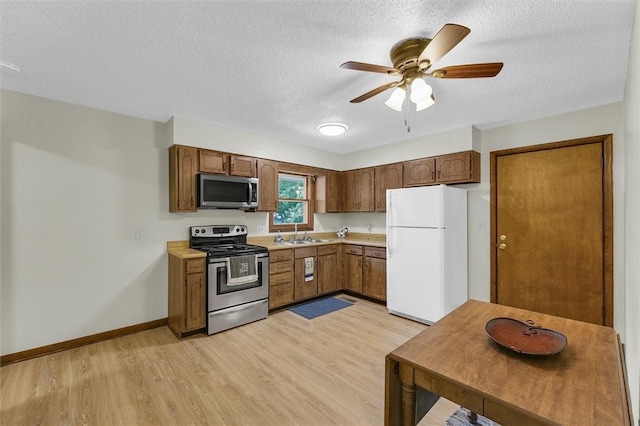 946 Foxcrest Dr, Charleston, IL 61920 - kitchen with appliances with stainless steel finishes, light wood-type flooring, a textured ceiling, light countertops, and a ceiling fan