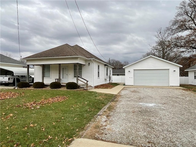 view of front of property with a front yard, a garage, a porch, and an outdoor structure