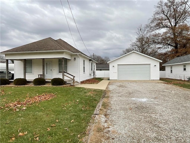 bungalow-style house featuring a garage, a front yard, an outdoor structure, and covered porch