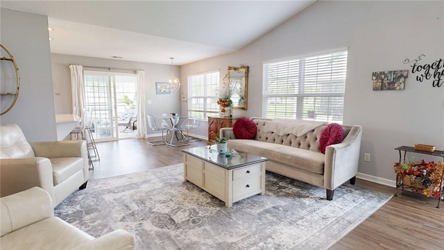 living area with baseboards, a chandelier, and light wood-style floors