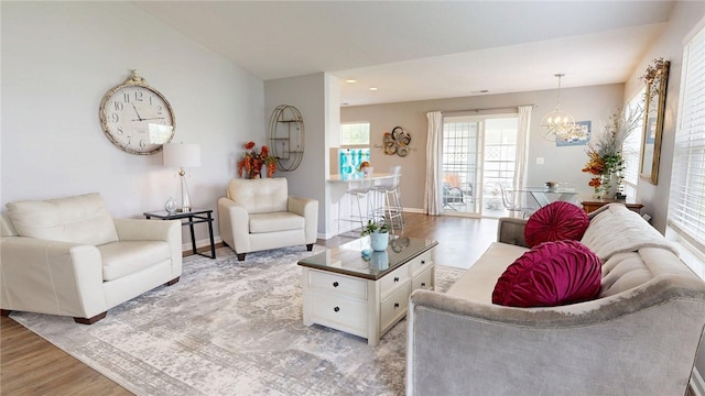 living room with baseboards, a chandelier, and light wood-type flooring