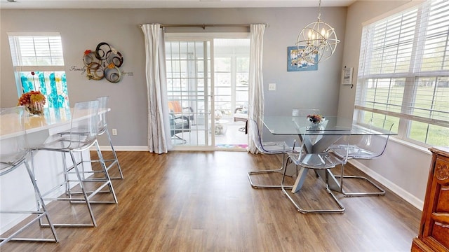 dining room featuring an inviting chandelier, baseboards, and wood finished floors