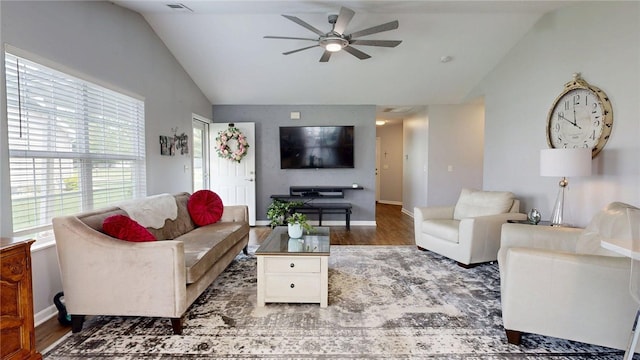living room featuring a ceiling fan, visible vents, vaulted ceiling, wood finished floors, and baseboards