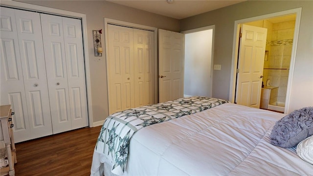 bedroom featuring multiple closets, baseboards, dark wood-style flooring, and connected bathroom
