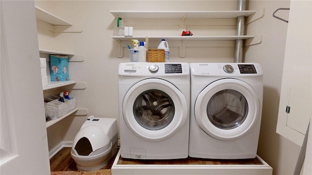 laundry room featuring baseboards, washer and clothes dryer, laundry area, and wood finished floors