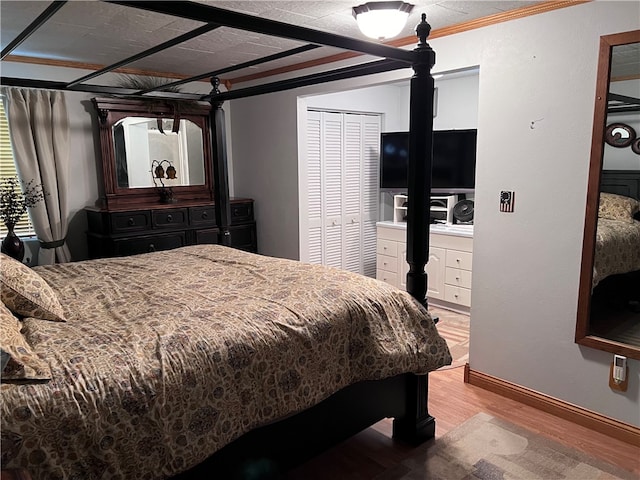 bedroom featuring a closet, crown molding, and light hardwood / wood-style flooring