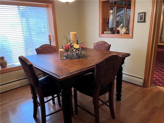 dining space featuring a baseboard radiator and light wood-type flooring