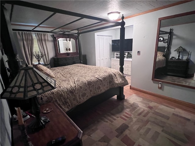 bedroom with hardwood / wood-style flooring, a closet, and ornamental molding