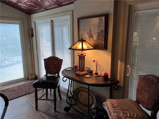 sitting room featuring tile patterned floors and lofted ceiling