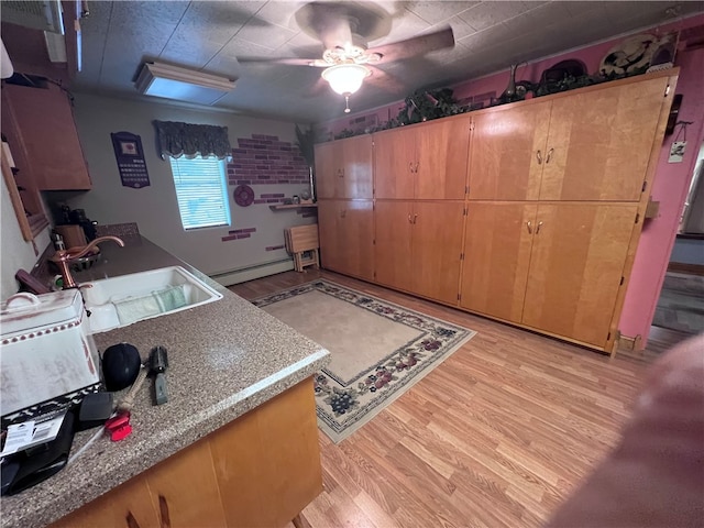 kitchen with ceiling fan, baseboard heating, sink, and light hardwood / wood-style flooring