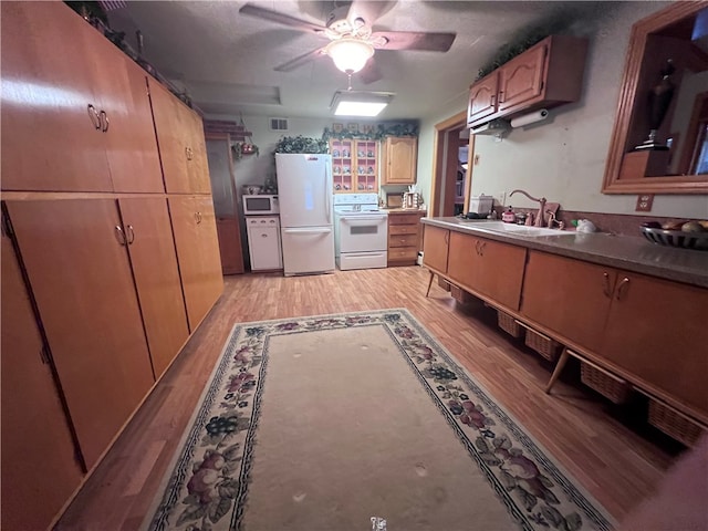 kitchen with white appliances, sink, ceiling fan, a textured ceiling, and light hardwood / wood-style floors