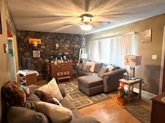 living area featuring a textured ceiling, wood finished floors, and a ceiling fan