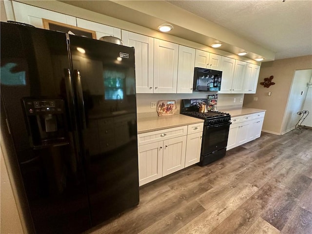 1712 Southdale Dr, Mattoon, IL 61938 - kitchen featuring black appliances, light countertops, dark wood-type flooring, white cabinets, and a textured ceiling
