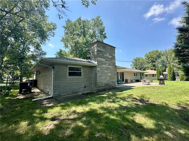 1712 Southdale Dr, Mattoon, IL 61938 - rear view of property with stone siding, a patio area, a chimney, and a lawn