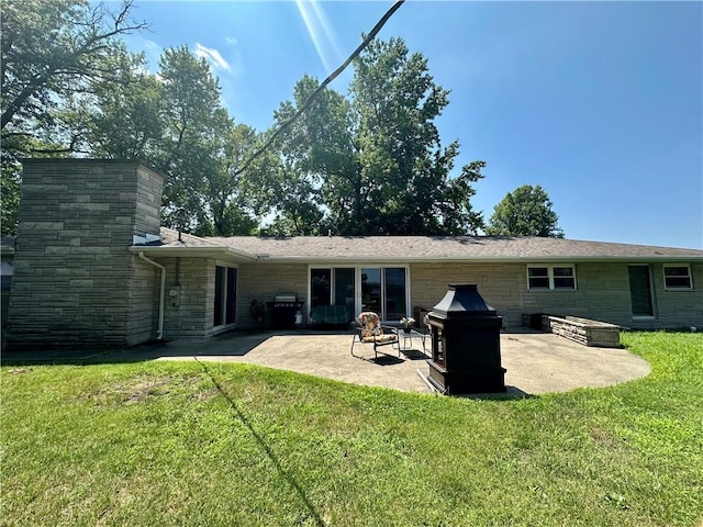 1712 Southdale Dr, Mattoon, IL 61938 - back of house featuring a patio, stone siding, a lawn, and a chimney