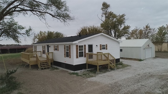 back of property featuring an outdoor structure, a deck, and a garage