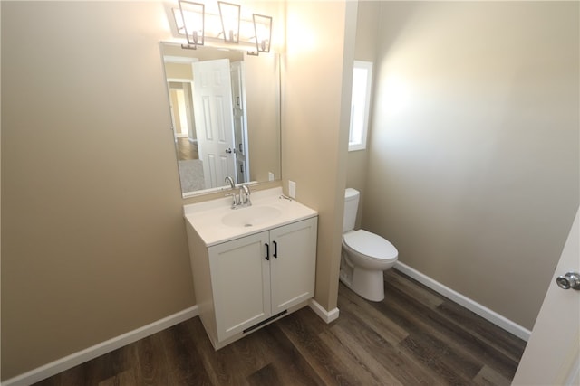 bathroom with toilet, vanity, and hardwood / wood-style flooring