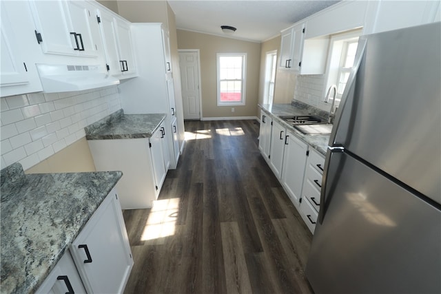 kitchen featuring sink, dark hardwood / wood-style flooring, backsplash, stainless steel fridge, and white cabinets