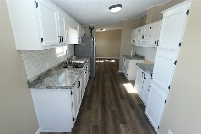 kitchen featuring backsplash, white cabinets, sink, a textured ceiling, and dark hardwood / wood-style flooring