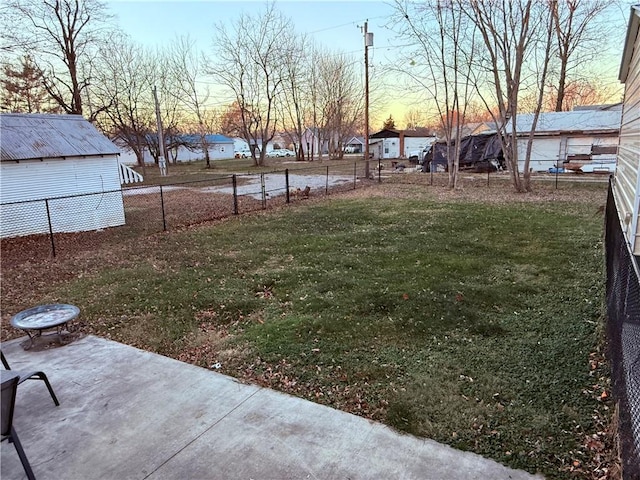 yard at dusk featuring a patio