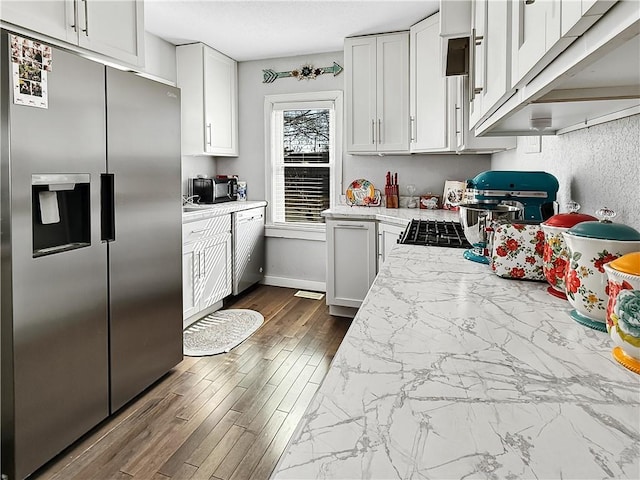 kitchen featuring white cabinetry, baseboards, and stainless steel fridge