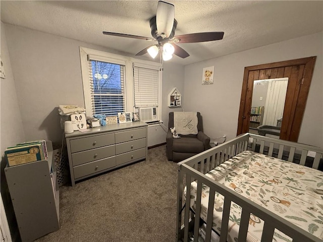 carpeted bedroom featuring ceiling fan, cooling unit, a textured ceiling, and a nursery area