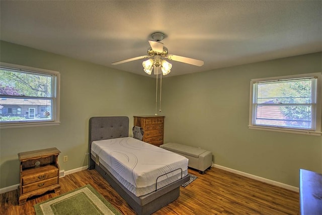 bedroom featuring baseboards, ceiling fan, and wood finished floors