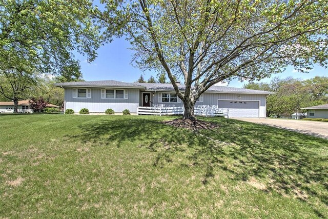 ranch-style home featuring a garage, concrete driveway, and a front yard