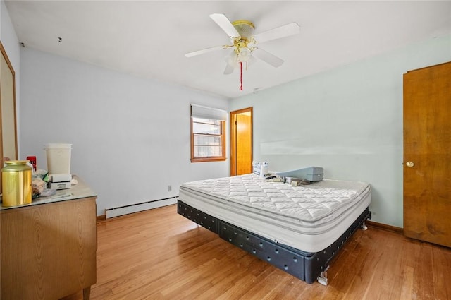 516 E Monroe Ave, Chrisman, IL 61924 - bedroom with a baseboard radiator, light wood-type flooring, ceiling fan, and baseboards