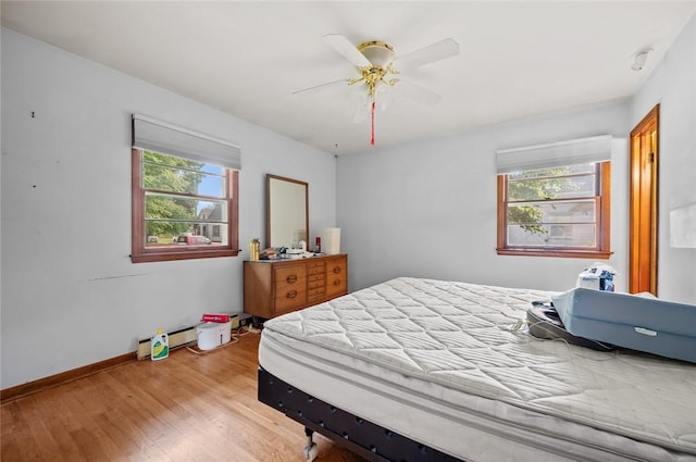 516 E Monroe Ave, Chrisman, IL 61924 - bedroom featuring multiple windows, wood finished floors, ceiling fan, and baseboards