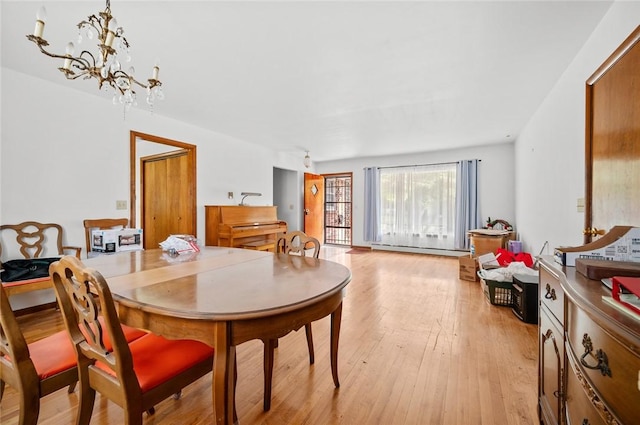 516 E Monroe Ave, Chrisman, IL 61924 - dining space featuring light wood-type flooring, a baseboard radiator, and a chandelier