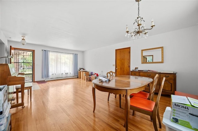 516 E Monroe Ave, Chrisman, IL 61924 - dining area featuring a baseboard heating unit, light wood-type flooring, and a chandelier