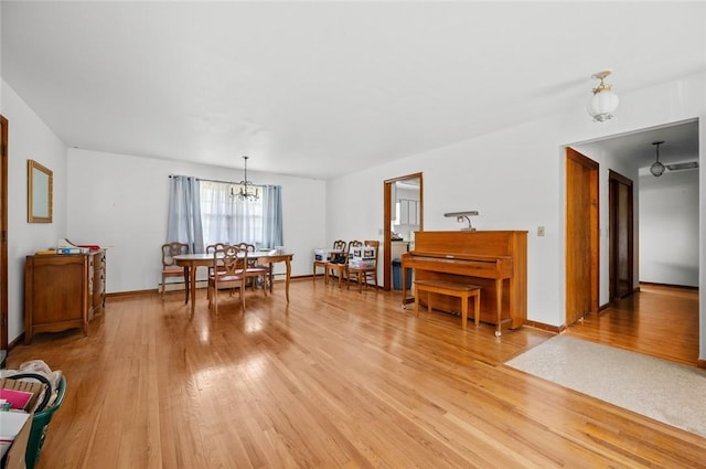 516 E Monroe Ave, Chrisman, IL 61924 - dining space with a chandelier, light wood-style flooring, and baseboards