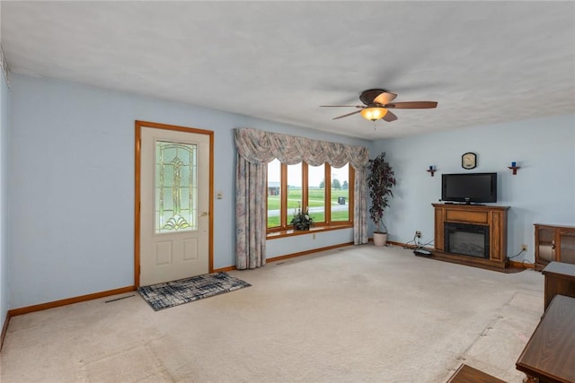 307 Gehle St, Saint Peter, IL 62880 - unfurnished living room with ceiling fan, baseboards, a glass covered fireplace, and carpet flooring