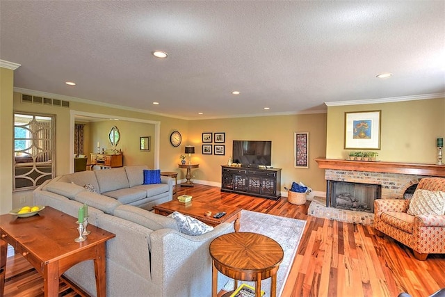 95 Hickory Point Ct, Forsyth, IL 62535 - living area featuring wood finished floors, recessed lighting, a brick fireplace, ornamental molding, and a textured ceiling
