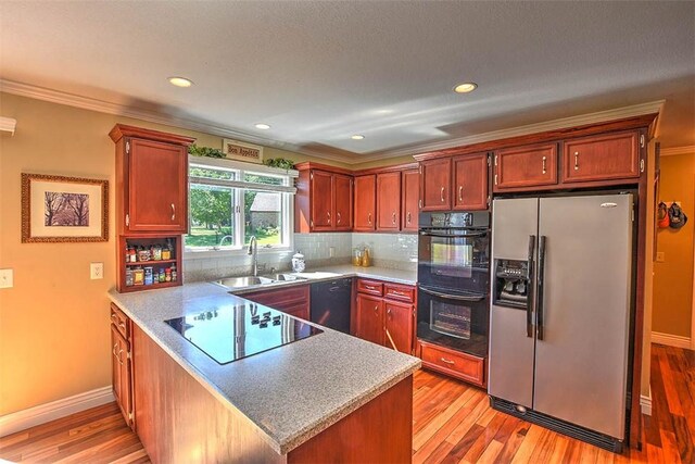 95 Hickory Point Ct, Forsyth, IL 62535 - kitchen with black appliances, a peninsula, light wood-style flooring, backsplash, and ornamental molding