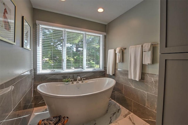 95 Hickory Point Ct, Forsyth, IL 62535 - full bath featuring tile walls, a freestanding tub, marble finish flooring, wainscoting, and recessed lighting