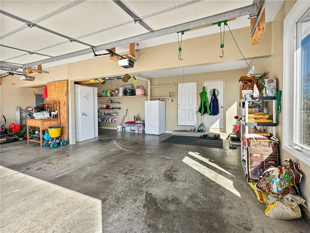 garage with a garage door opener and freestanding refrigerator
