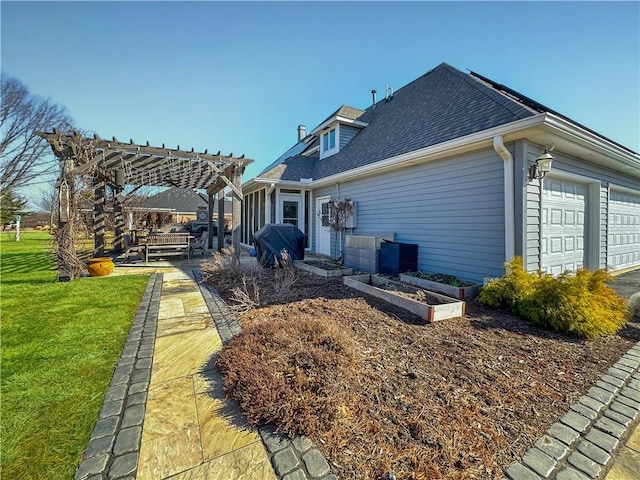 back of property featuring a shingled roof, a yard, a garage, a pergola, and a patio