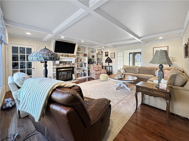 living area featuring a stone fireplace, beamed ceiling, wood finished floors, and coffered ceiling