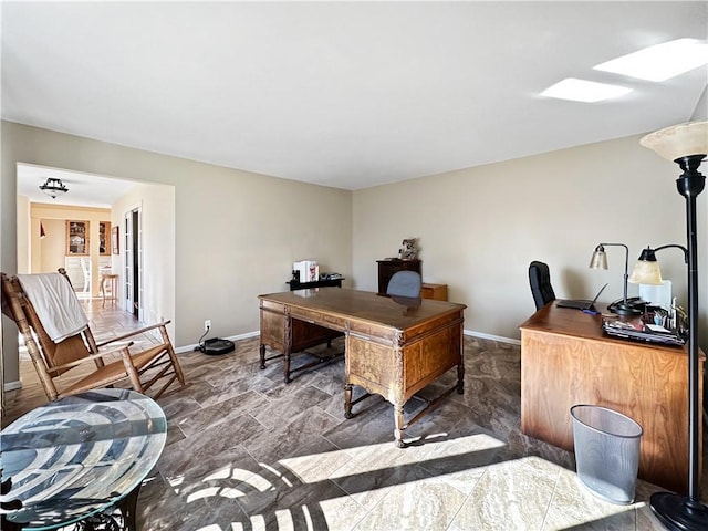 home office featuring a skylight and baseboards