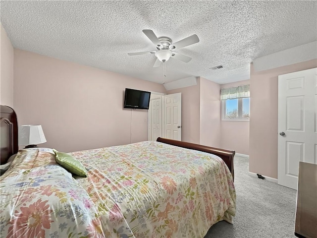 carpeted bedroom featuring visible vents, a ceiling fan, baseboards, and a textured ceiling