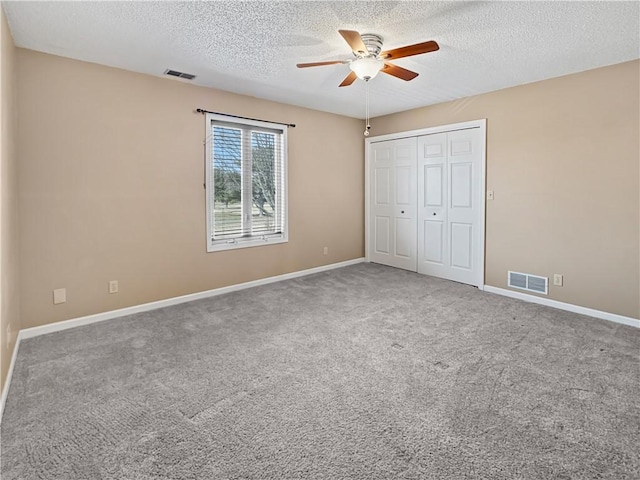 unfurnished bedroom with carpet, visible vents, a closet, and baseboards