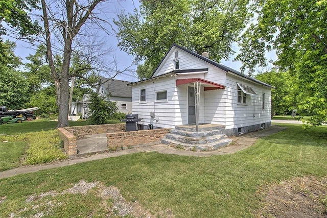 1212 Washington St, Clinton, IL 61727 - view of front of house with a front yard and a chimney