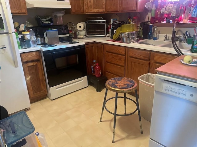 kitchen with sink, white appliances, and range hood