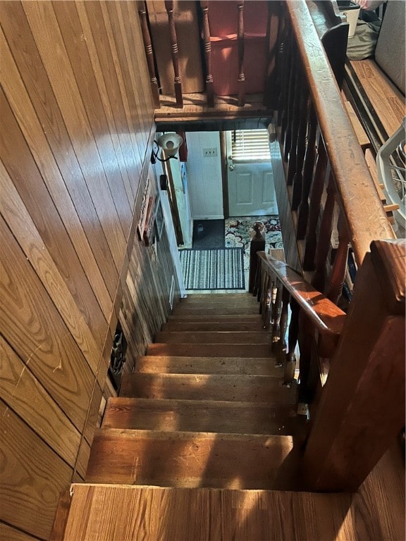 stairs with hardwood / wood-style flooring and wooden walls