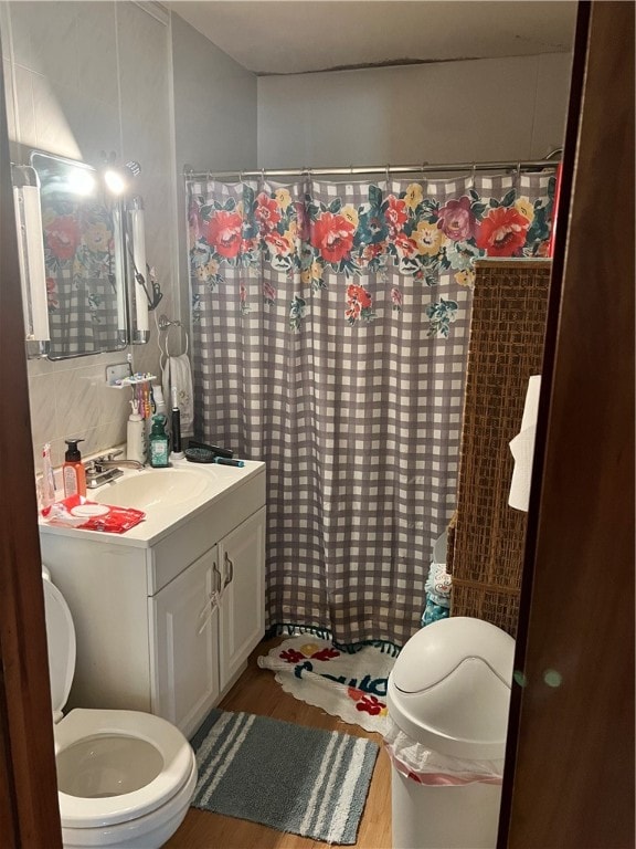 bathroom featuring a shower with shower curtain, vanity, hardwood / wood-style flooring, and toilet