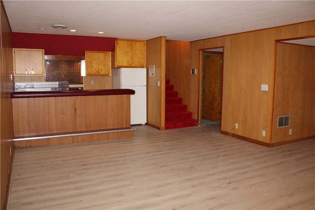 1011 W N 3rd St, Shelbyville, IL 62565 - kitchen featuring freestanding refrigerator, light wood-style floors, dark countertops, wooden walls, and brown cabinets