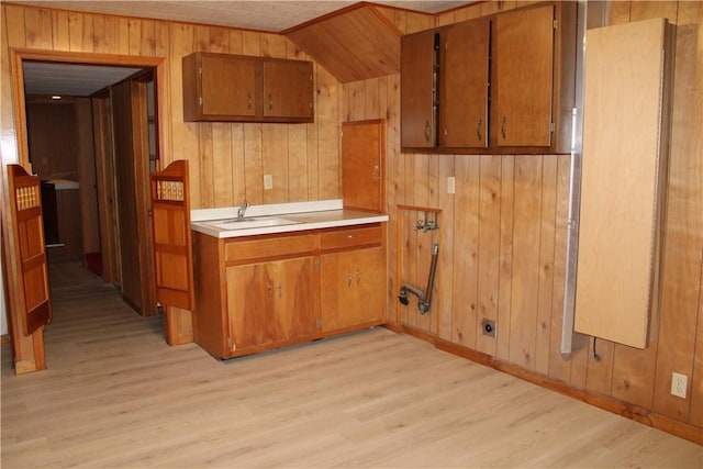 1011 W N 3rd St, Shelbyville, IL 62565 - kitchen with brown cabinets, wooden walls, light wood-type flooring, light countertops, and a sink