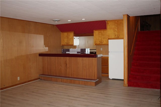 1011 W N 3rd St, Shelbyville, IL 62565 - kitchen with freestanding refrigerator, brown cabinetry, wooden walls, a peninsula, and wood finished floors